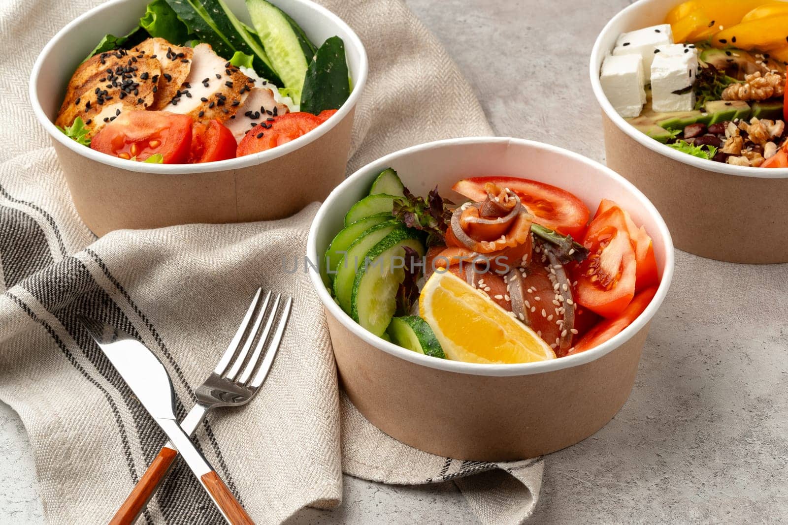 Beautiful composition with poke bowls on gray background with napkin close up
