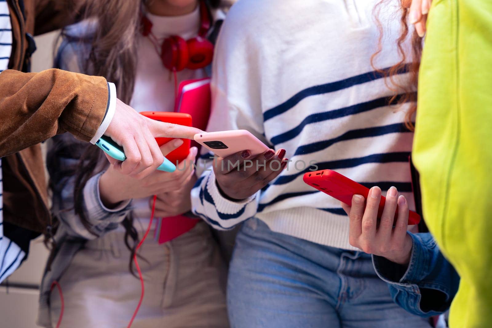 unrecognizable students having fun with mobile phones creating content on social media. by mariaphoto3