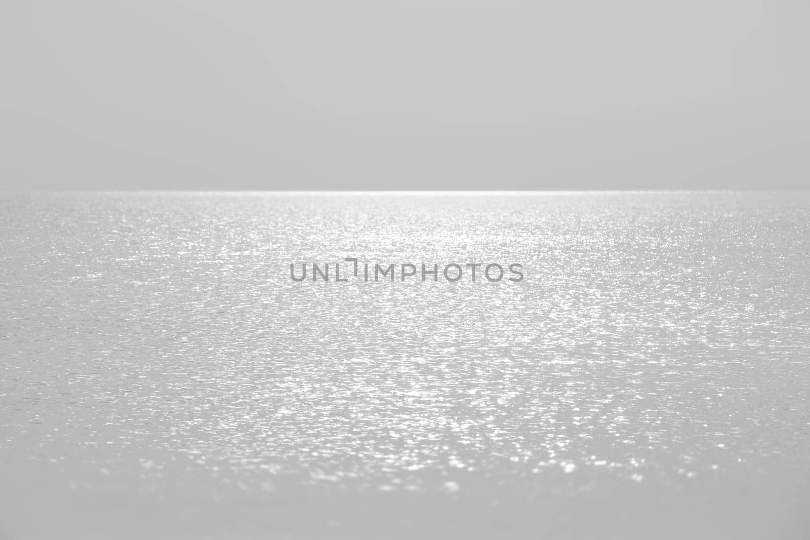 Sun glare on the sea surface in calm, breezy weather. Natural background and texture.