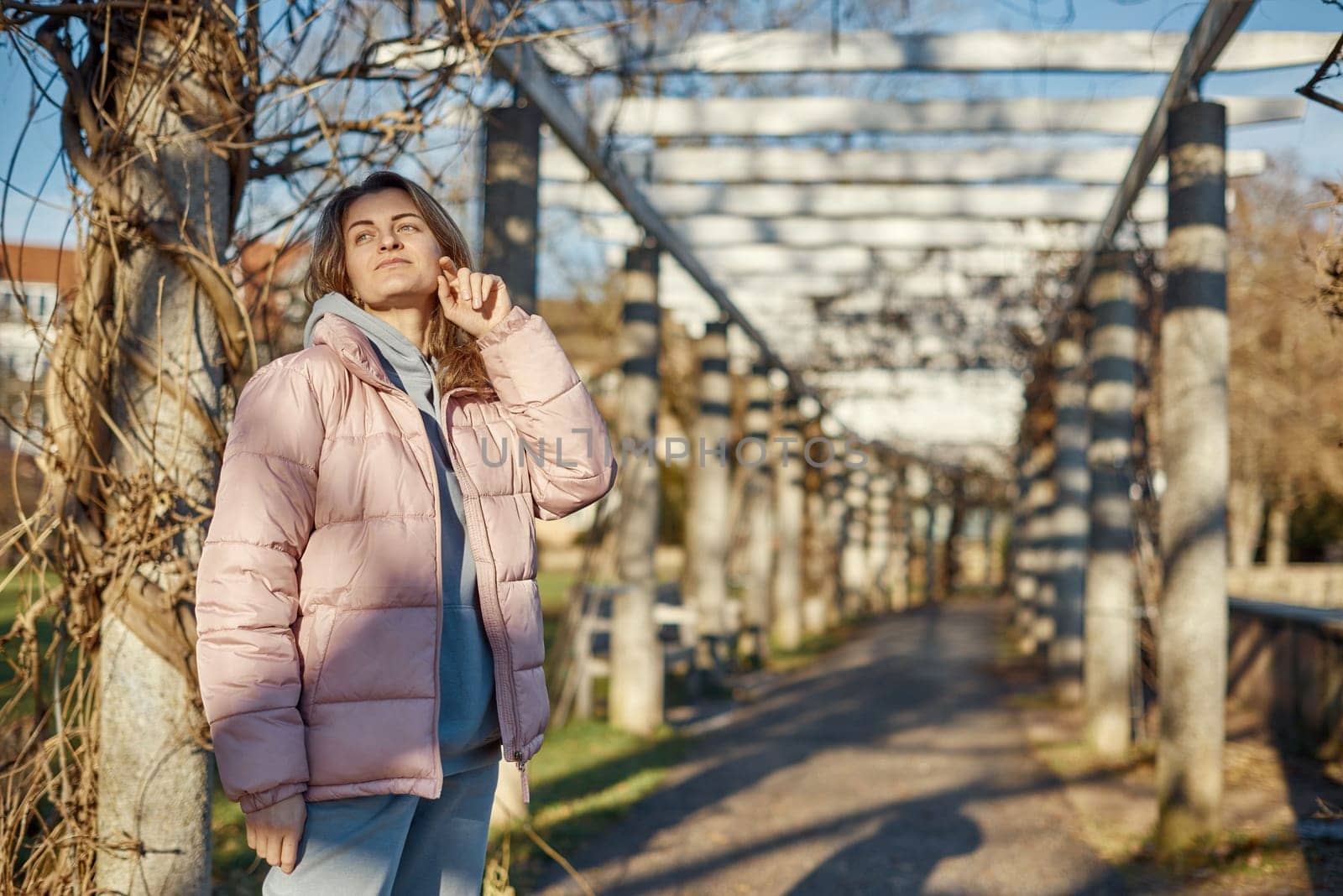 Winter Fun in Bitigheim-Bissingen: Beautiful Girl in Pink Jacket Amidst Half-Timbered Charm. a lovely girl in a pink winter jacket standing in the archway of the historic town of Bitigheim-Bissingen, Baden-Wurttemberg, Germany. by Andrii_Ko