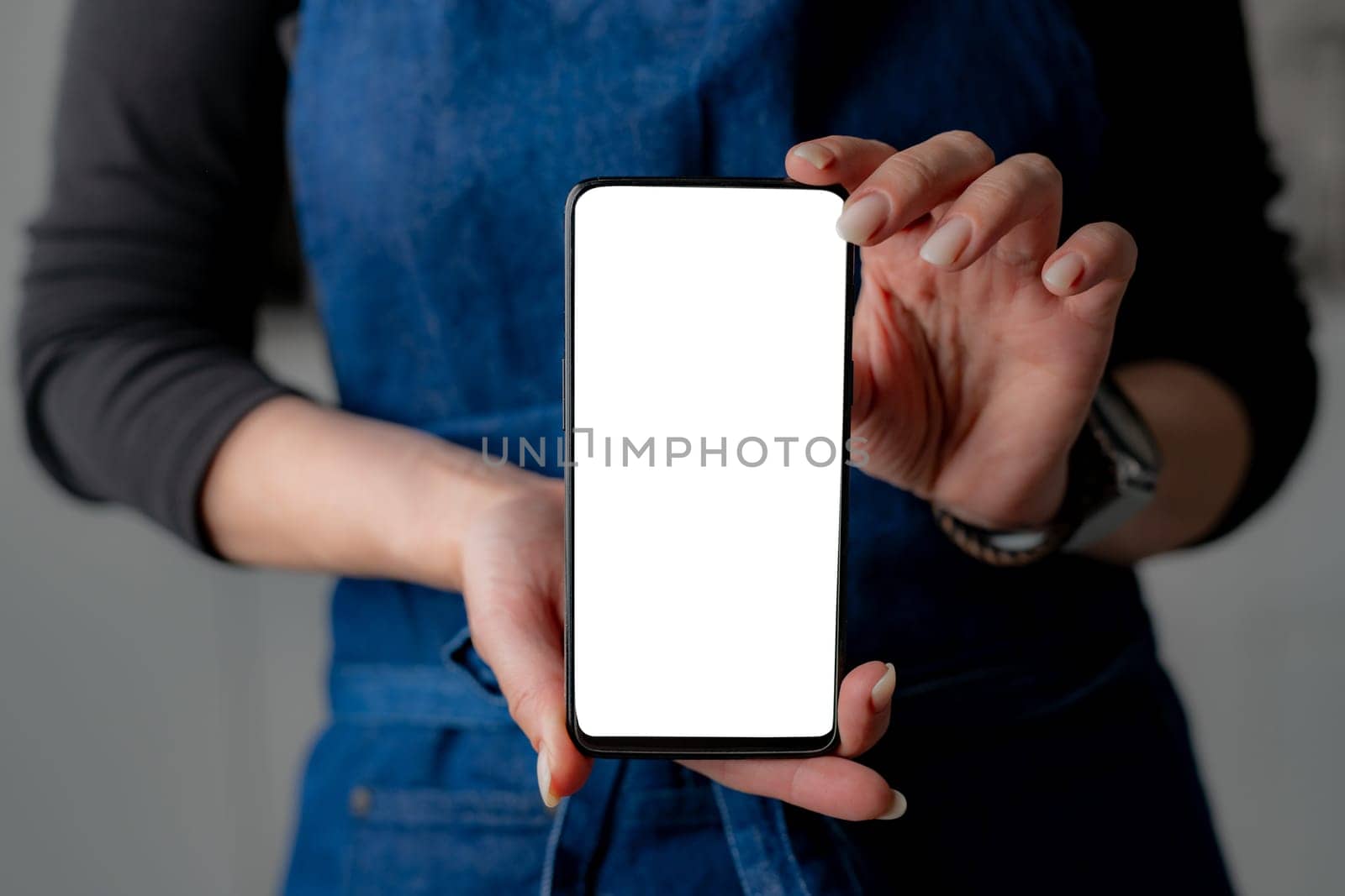 Woman In Stylish Forefront Shows Smartphone With White Screen In Close-Up View