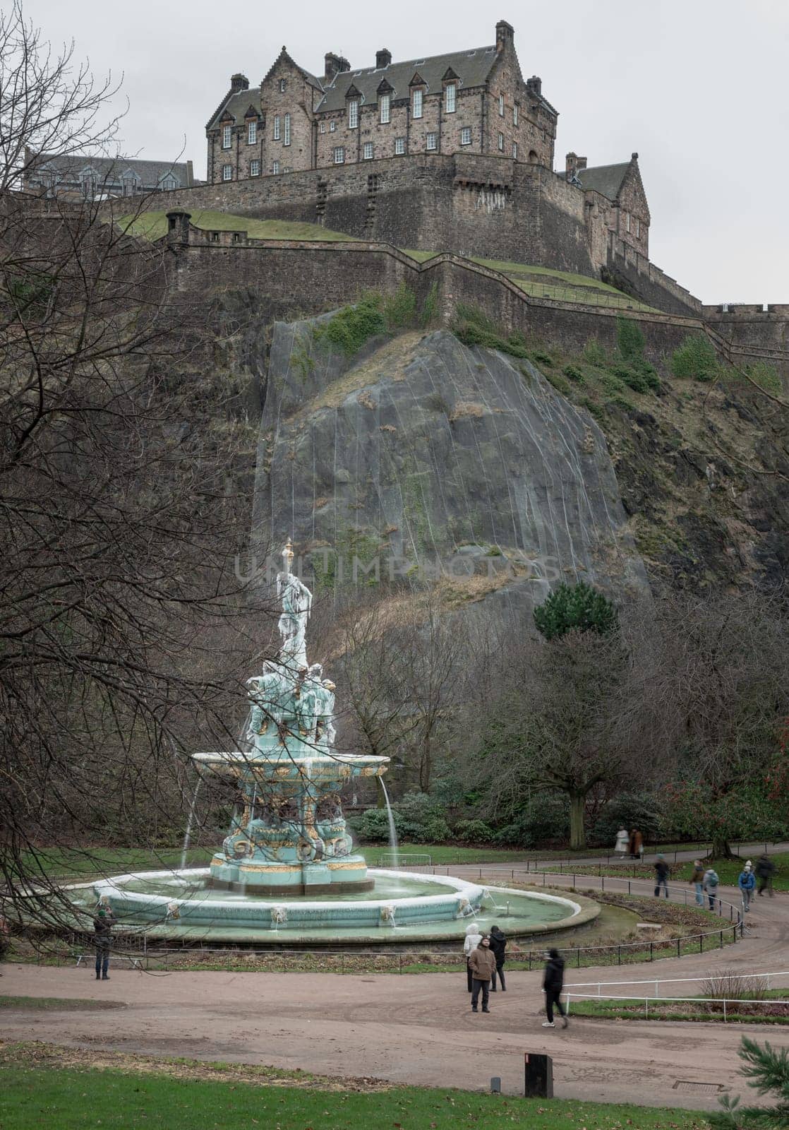 Edinburgh, Scotland - Jan 16, 2024 - Scenic view of Ross Fountain with Edinburgh Castle at the top of the hill at West Princes Street Garden in the centre of Edinburgh. is one of the most popular tourist attractions in Edinburgh, Space for text, Selective focus.
