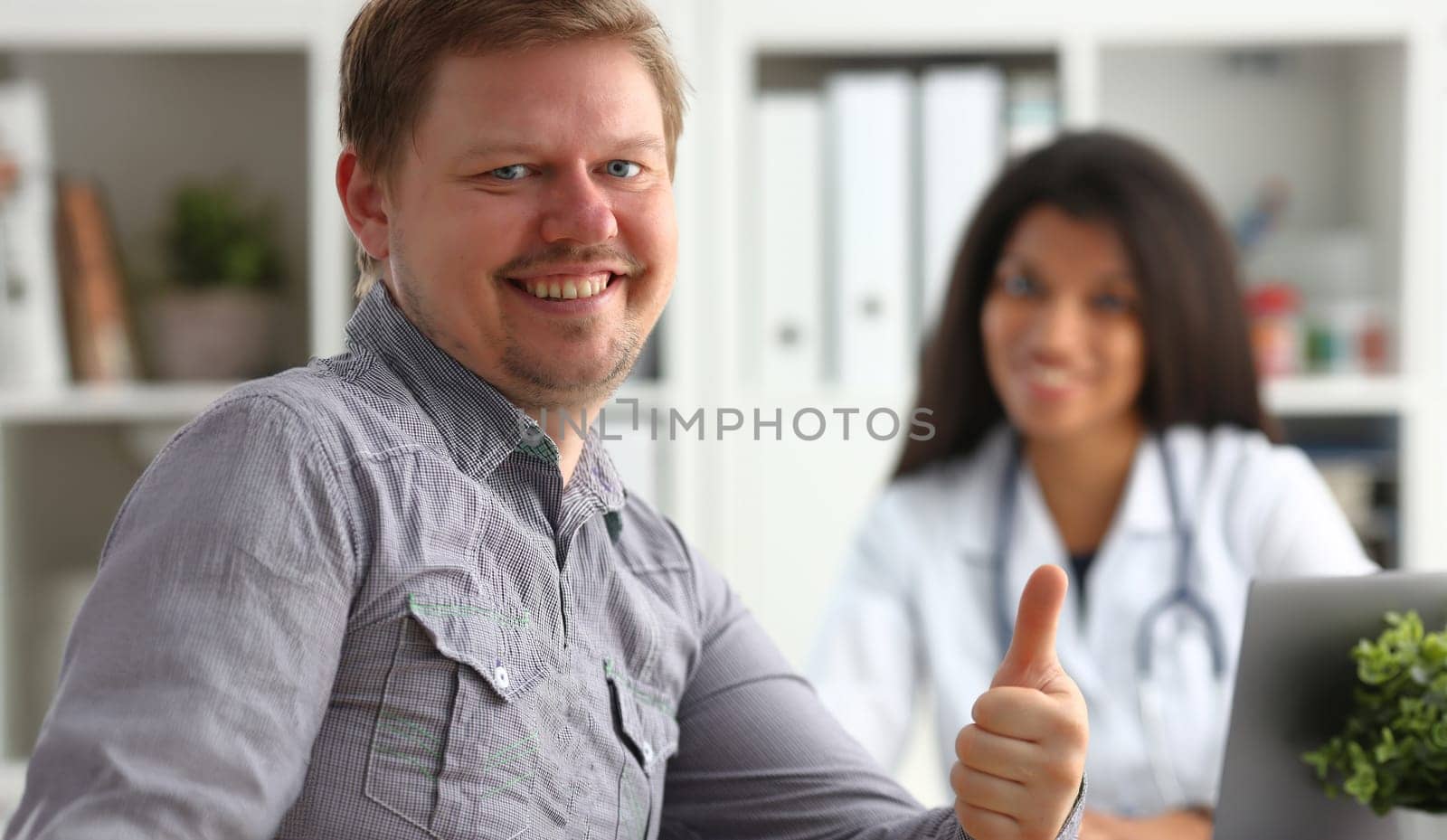 Man showing ok sign with thumb up at physician office portrait. High level work confident satisfied male do like visit to clinic best occupation emergency help teamwork concept