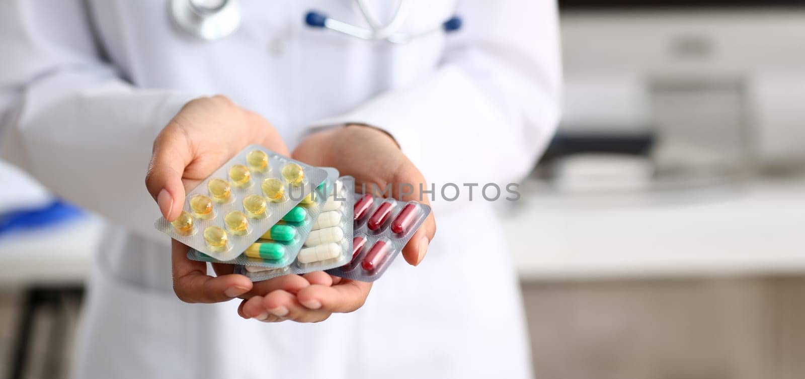 Female doctor hand holding pack of different tablet blisters at workplace closeup. Panacea life save service prescribe medicament legal drug store disease healing blood pressure concept
