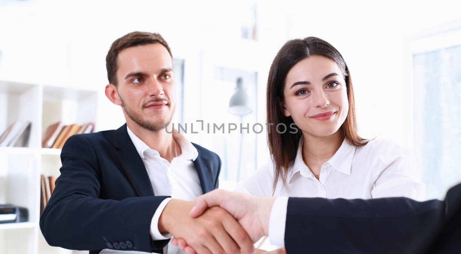 Smiling man in suit shake hands as hello in office portrait. Friend welcome mediation offer positive introduction greet or thanks gesture summit participate approval strike arm bargain concept