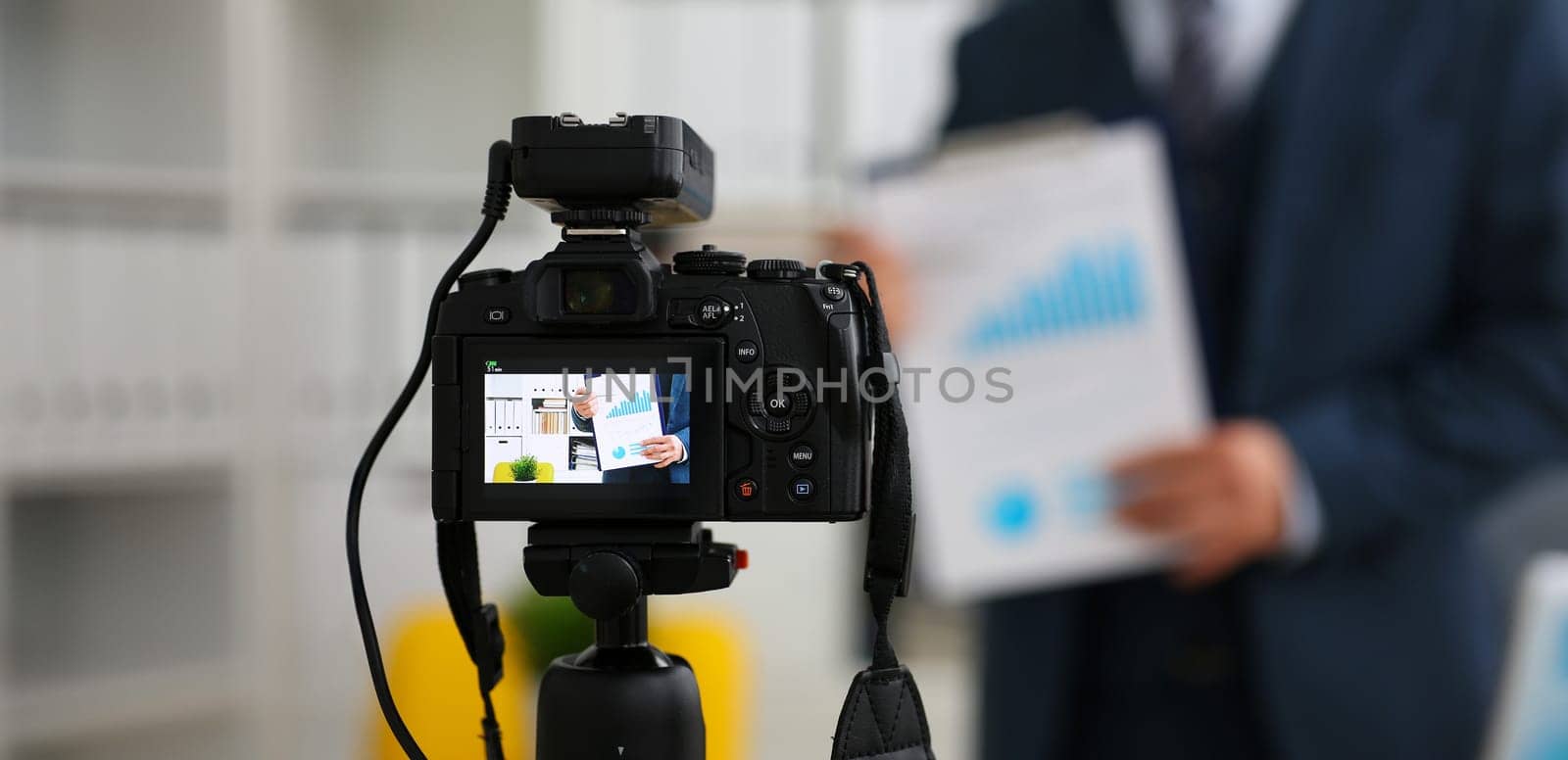 Male in suit and tie show stats graph pad making promo videoblog or photo session in office camcorder to tripod closeup. Vlogger selfie sale solution or finance advisor management information