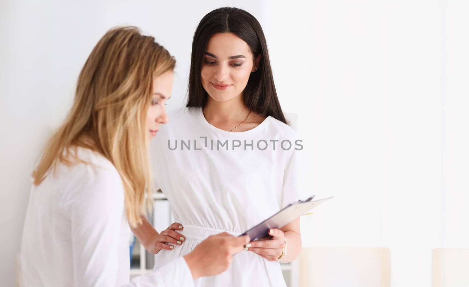 Group of people deliberate on problem with clipboard pad closeup. White collar check money papers stock exchange market earnings list partnership agreement discussion indian worker