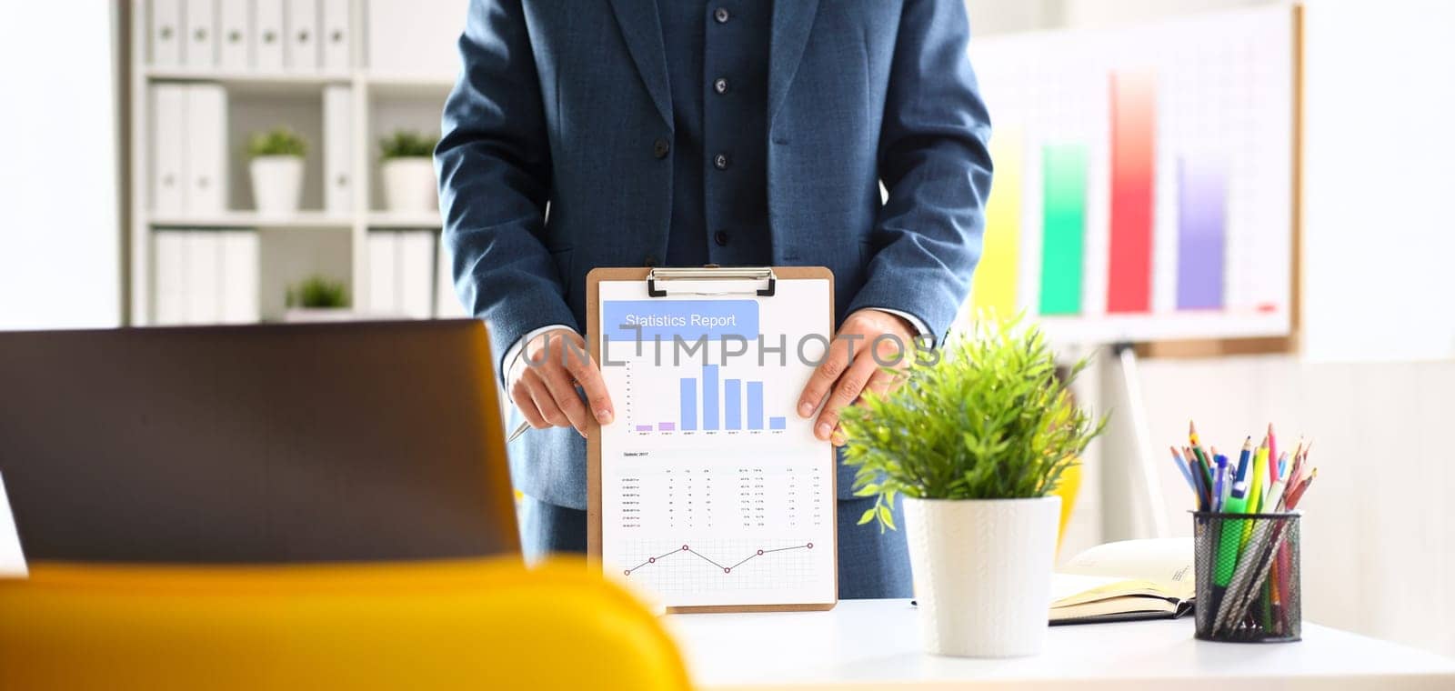 Male arm in suit show stats graphic clipped to pad in office closeup. Stock exchange market advisor participation in negotiation study trade process white collar inspector check or explain money data