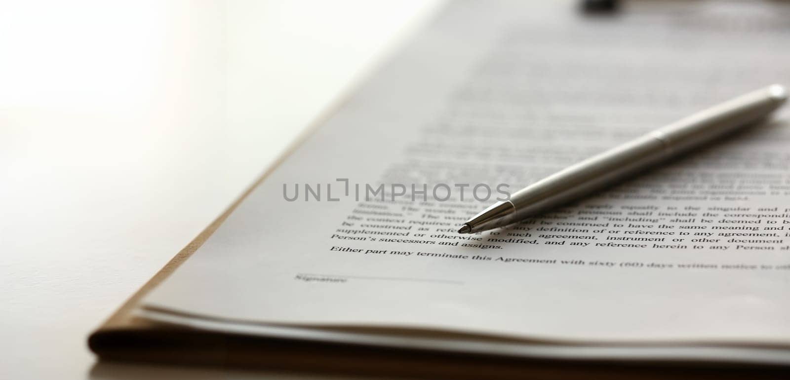 Silver pen lying on form clipped to pad closeup background. Sign gesture read pact sale agent bank job make note loan credit mortgage investment finance chief