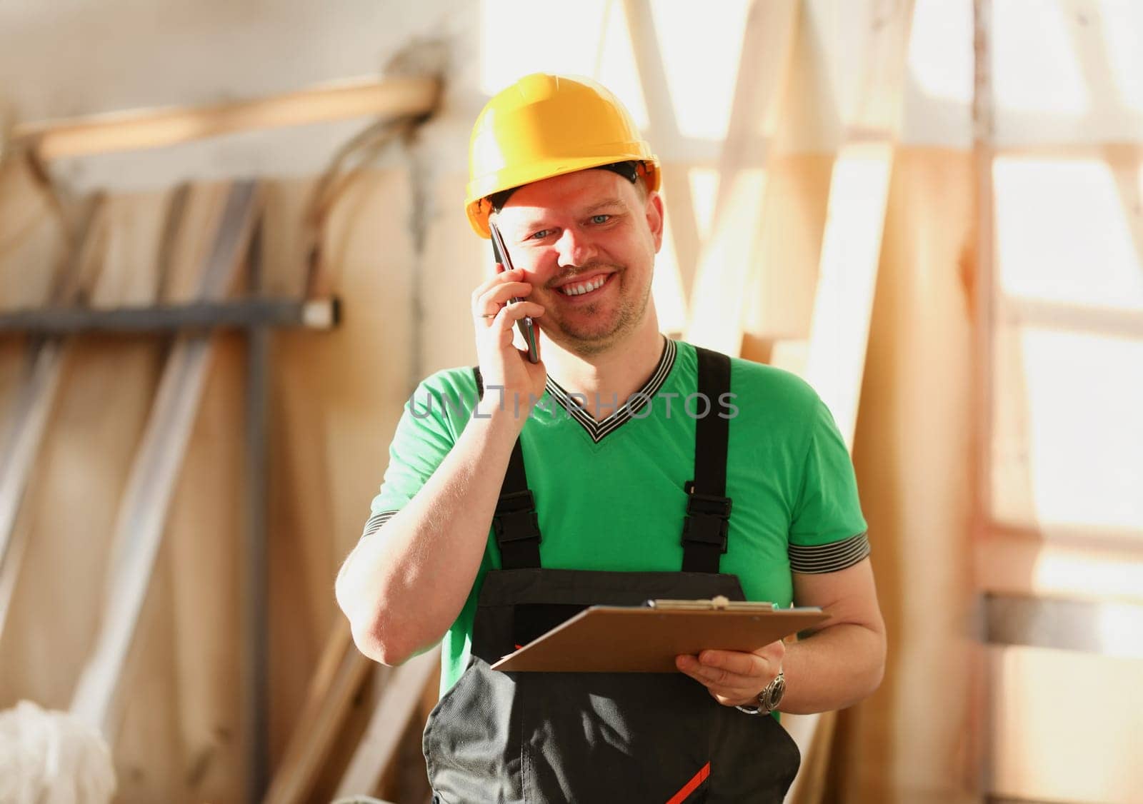 Carpenter talking on phone in hardware store furniture manufacturing takes an order