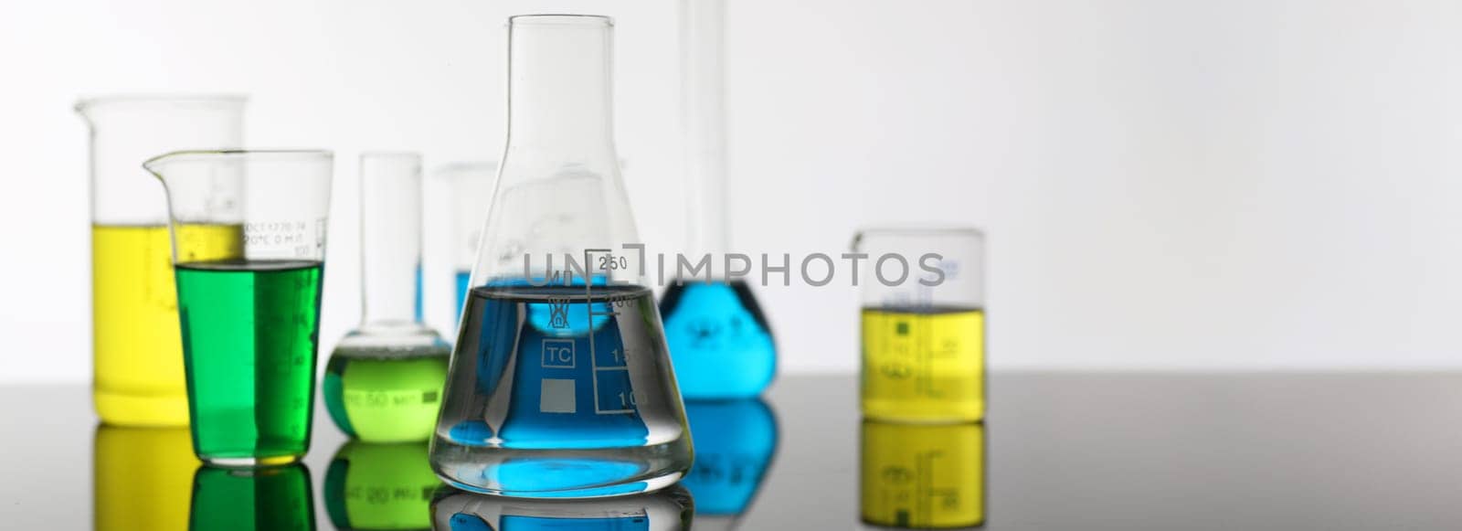 Chemical industry bulb with blue magenta pink liquid lab tubes stand on the table in the laboratory of liquid testing test development substances poisons additives stabilizers flavors house cleaning.