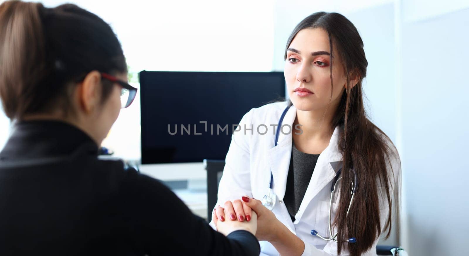 Young female doctor holds sick patient by hand expressing condolences and sympathy reports bad news about loss of loved ones due to cancer deadly aids disease and says we can handle support concept.