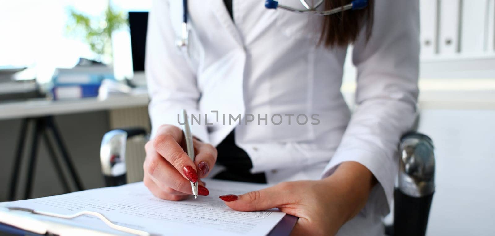 Female doctor hand hold silver pen filling patient history list at clipboard pad. Physical exam er disease prevention ward round visit check 911 prescribe remedy healthy lifestyle concept