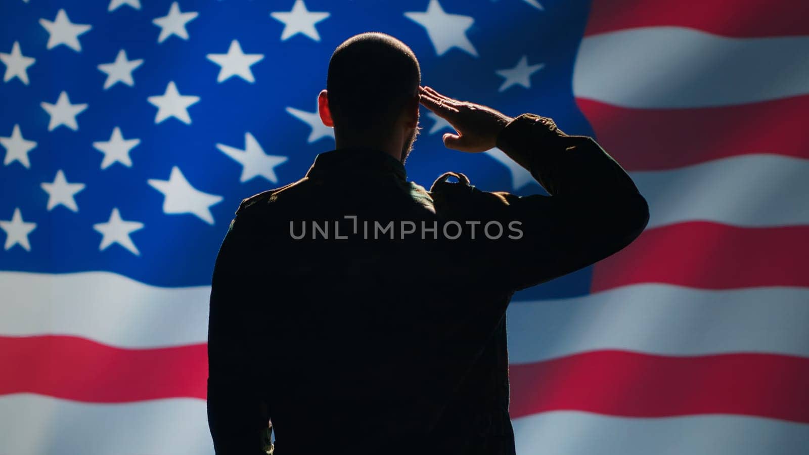 American soldier doing saluting hand gesture towards USA flag in command center, showing respect. Military unit in uniform serving in United States Armed Forces, doing patriotic gesturing, camera A