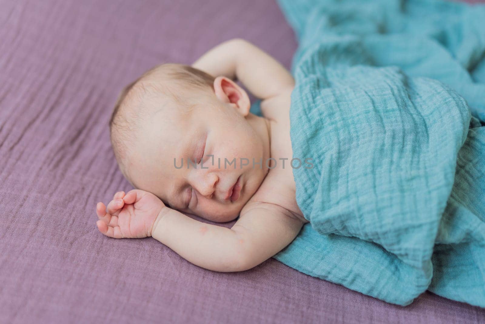 The baby is sleeping peacefully in his cozy nest. Newborn photo session captures the serene innocence and warmth of early moments.