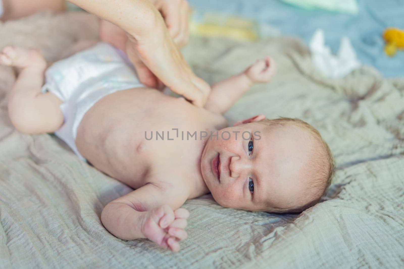 The newborn's skin is peeling. Mom uses skin products and massages to care for and soothe the baby's delicate skin, ensuring comfort and promoting healthy skin.