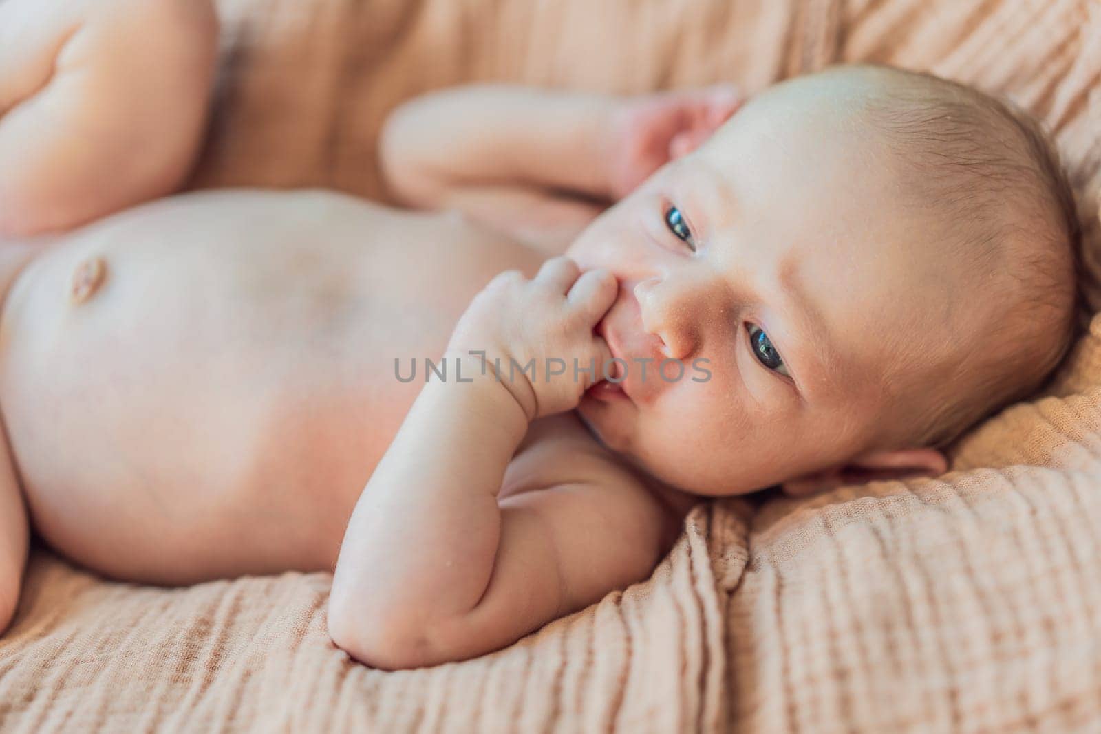 The baby is sleeping peacefully in his cozy nest. Newborn photo session captures the serene innocence and warmth of early moments.