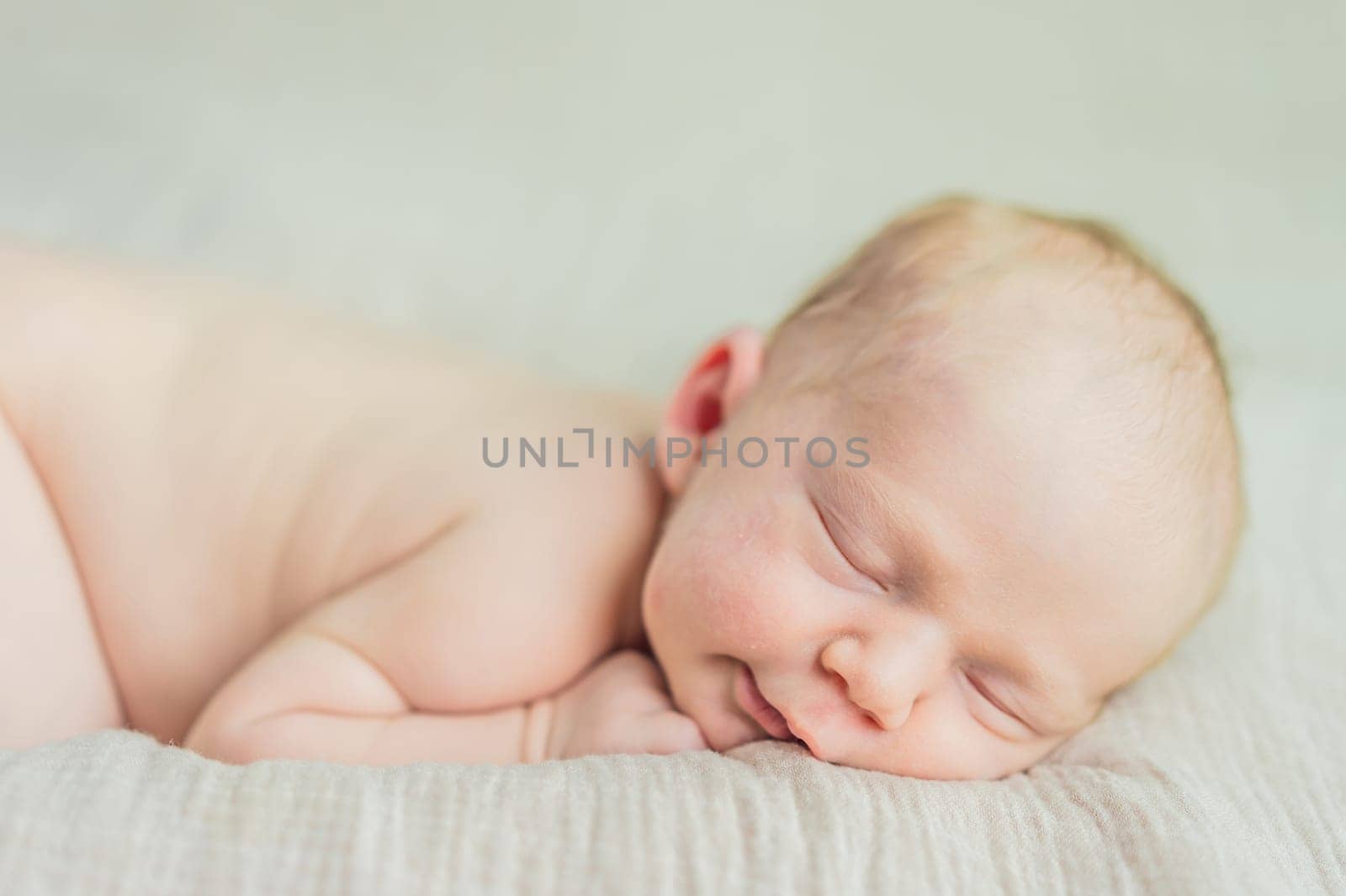 The baby is sleeping peacefully in his cozy nest. Newborn photo session captures the serene innocence and warmth of early moments.