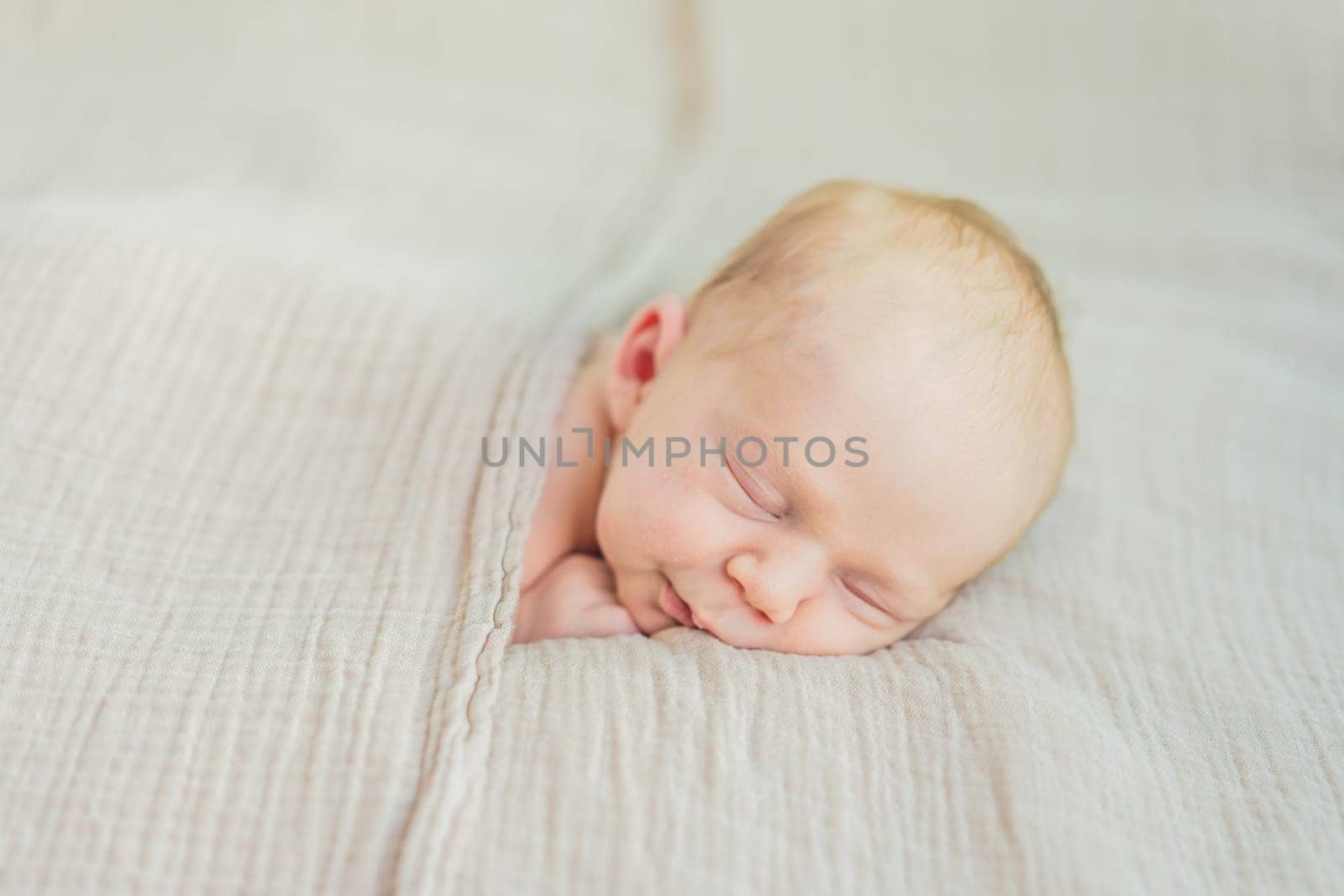 The baby is sleeping peacefully in his cozy nest. Newborn photo session captures the serene innocence and warmth of early moments.