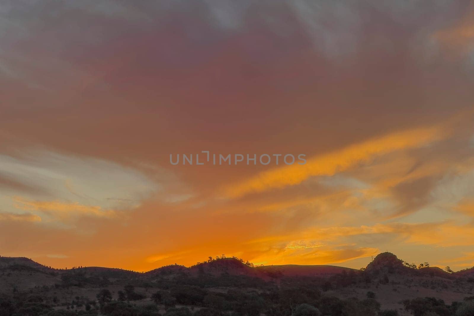 Stunning sunset paints the sky in vibrant hues over Alpana Station in the Flinders Ranges landscape.