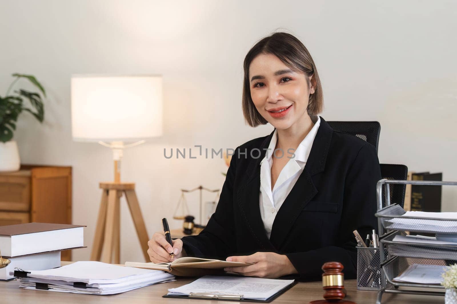 A professional female lawyer examines contract documents related to a lawsuit in a modern office environment.