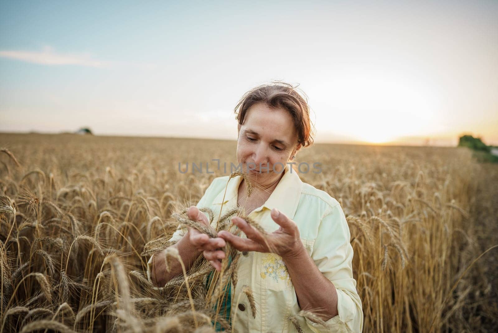 Happy farmer is satisfied with the high wheat harvest and hugs the ears of grain. Small grain producers received subsidies from the state.