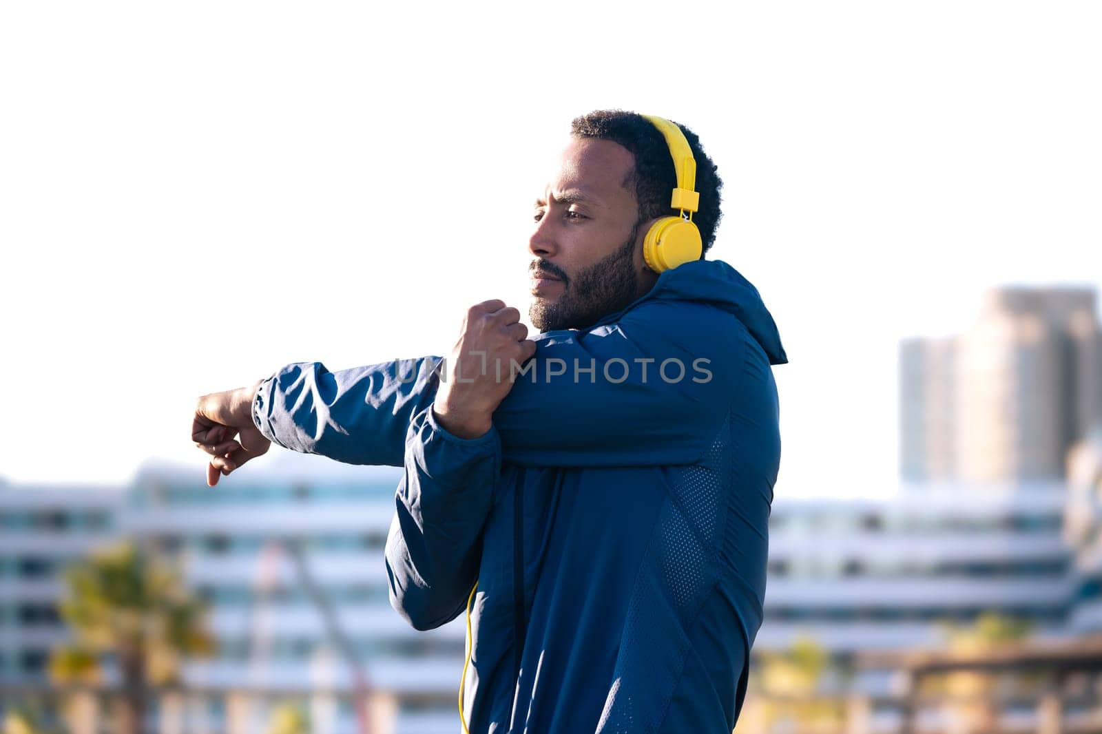 Side view latin male runner doing stretching exercises before running or doing cardio exercise.