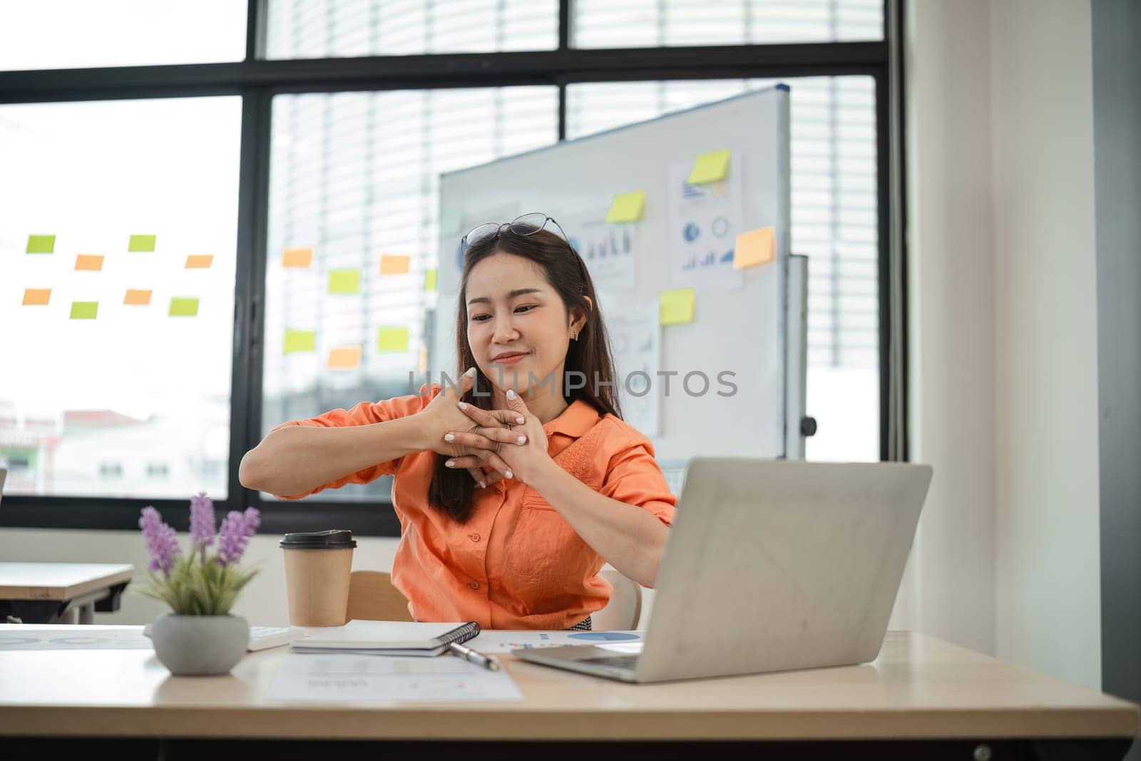 Professional female accountant analyzing financial documents at her desk in a contemporary office setting.