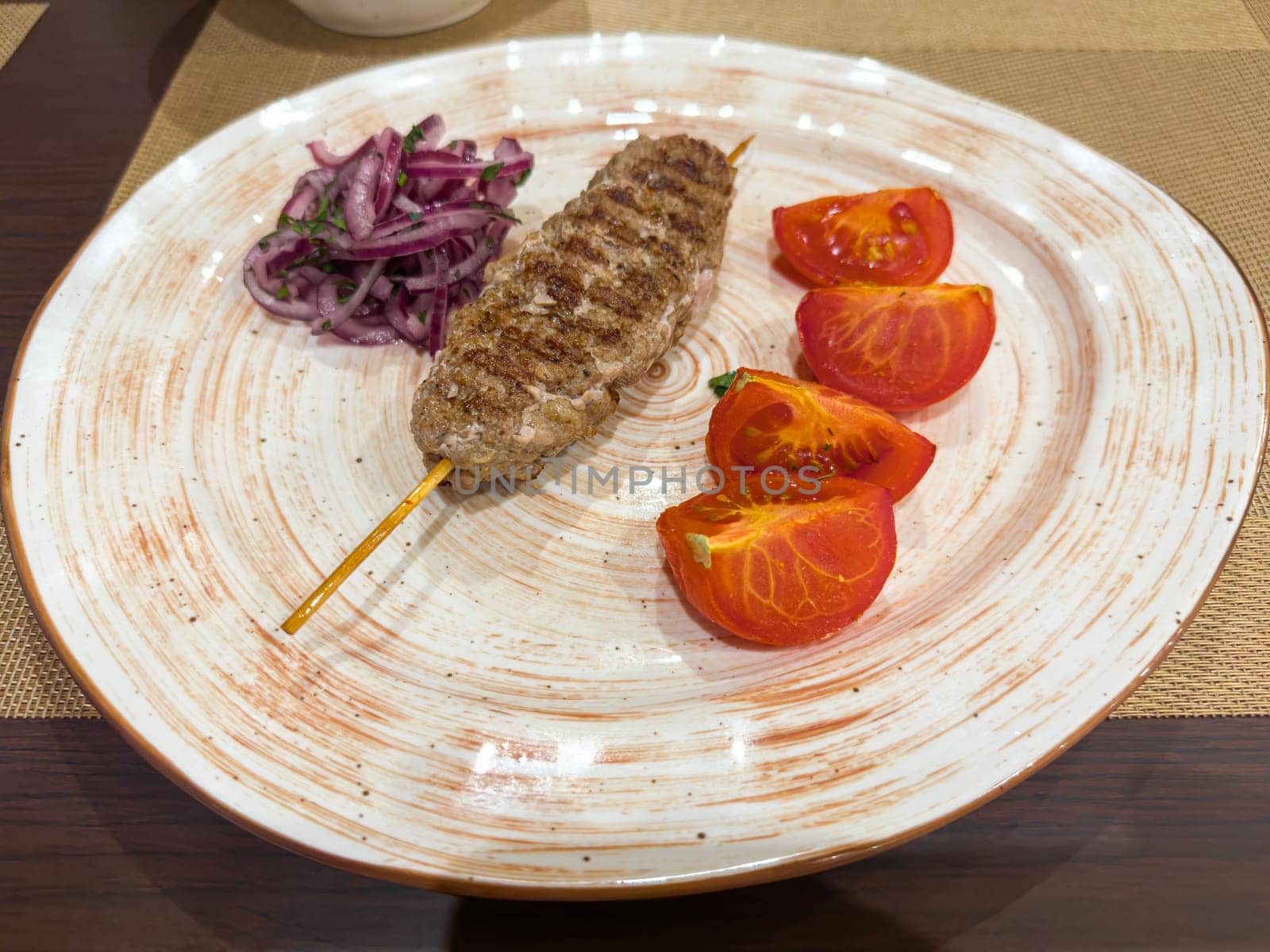 Kebapche . Garnished with cherry tomato and dressing.