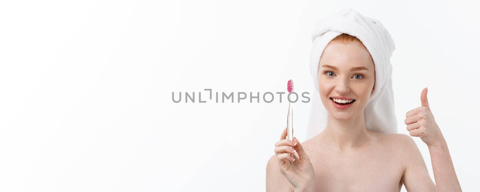 Portrait of young woman with toothbrush on grey background