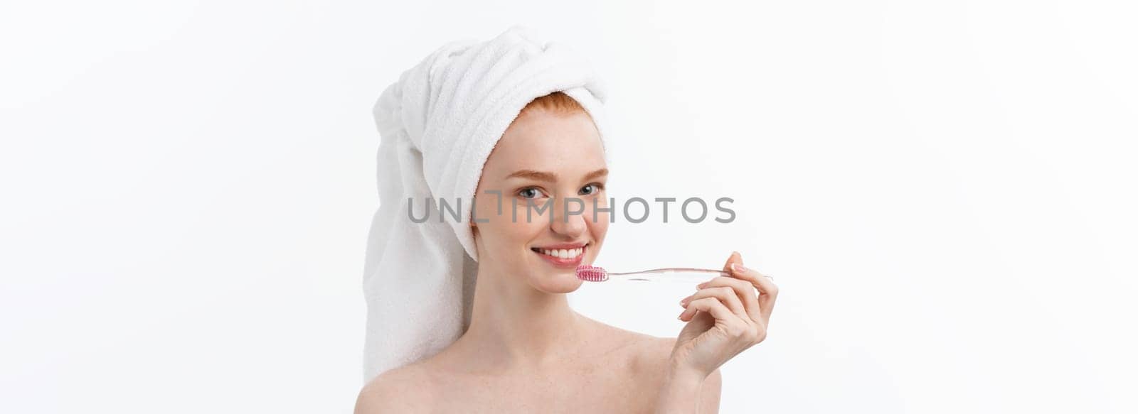 Portrait of young woman with toothbrush on grey background