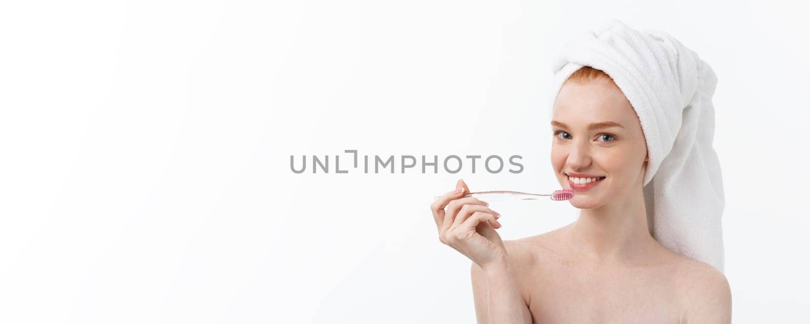 Portrait of young woman with toothbrush on grey background