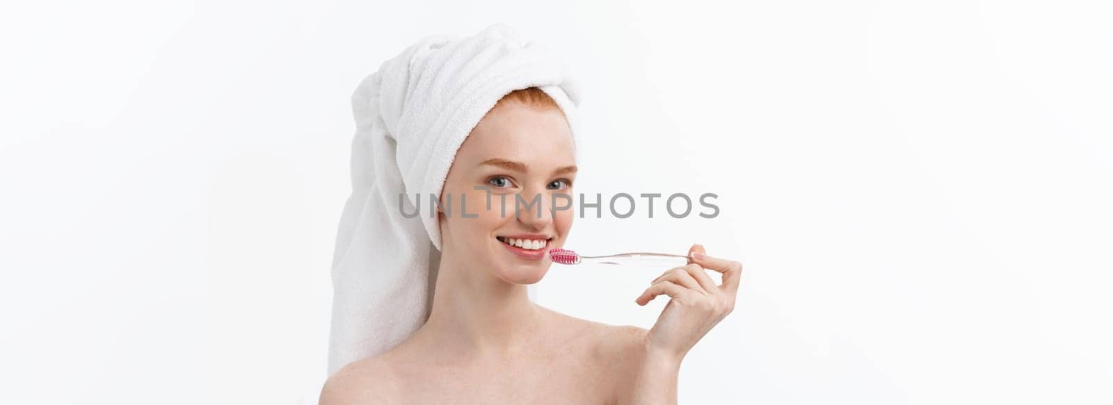 Portrait of young woman with toothbrush on grey background