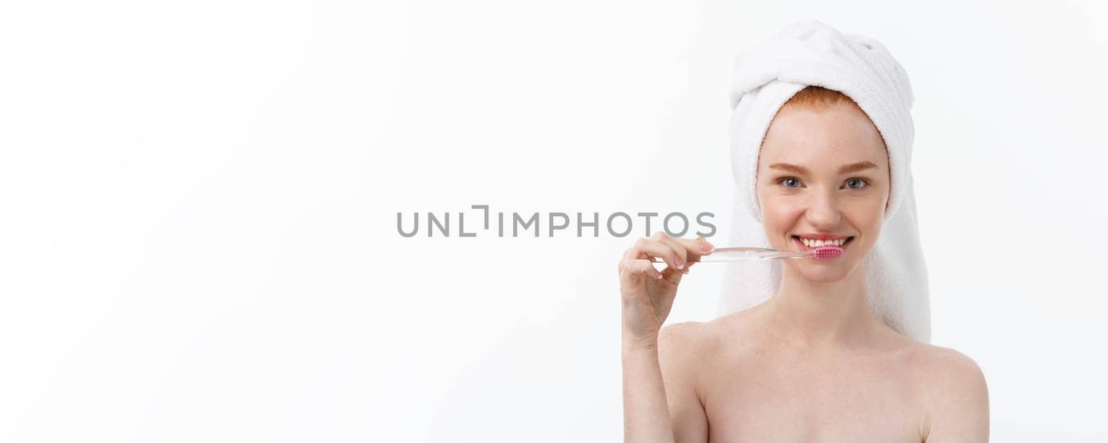 Portrait of young woman with toothbrush on grey background