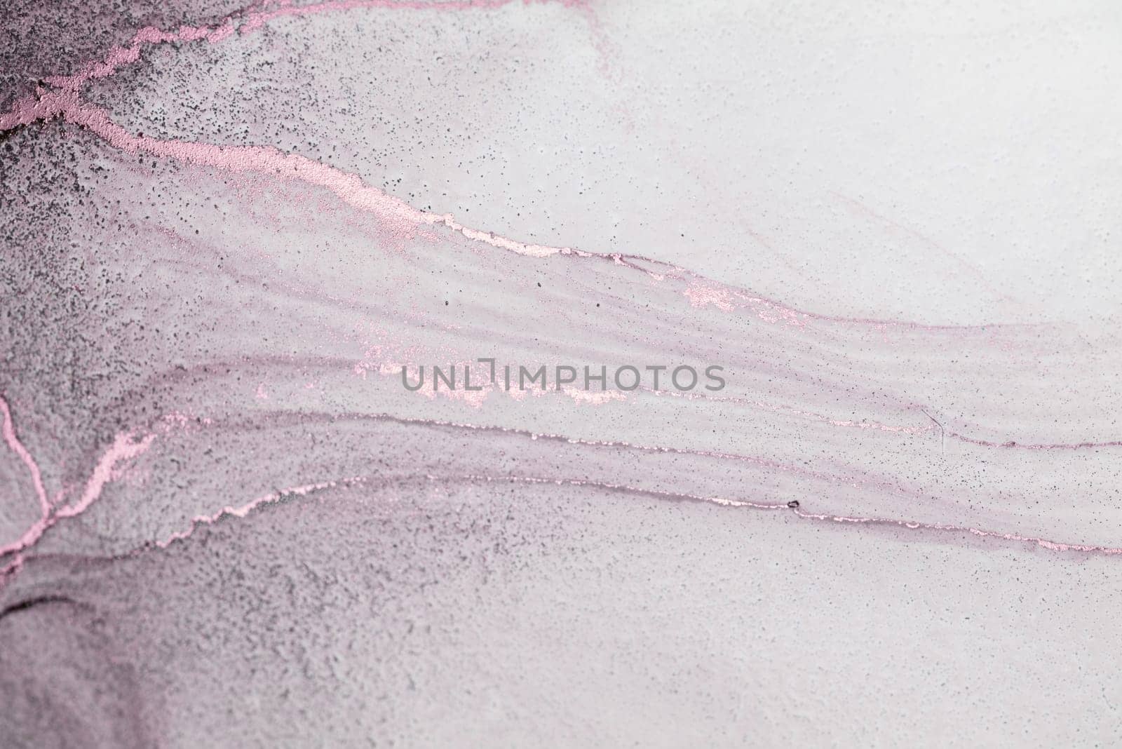 A close-up abstract image of a soft pink and white gradient background with thin, golden veins.