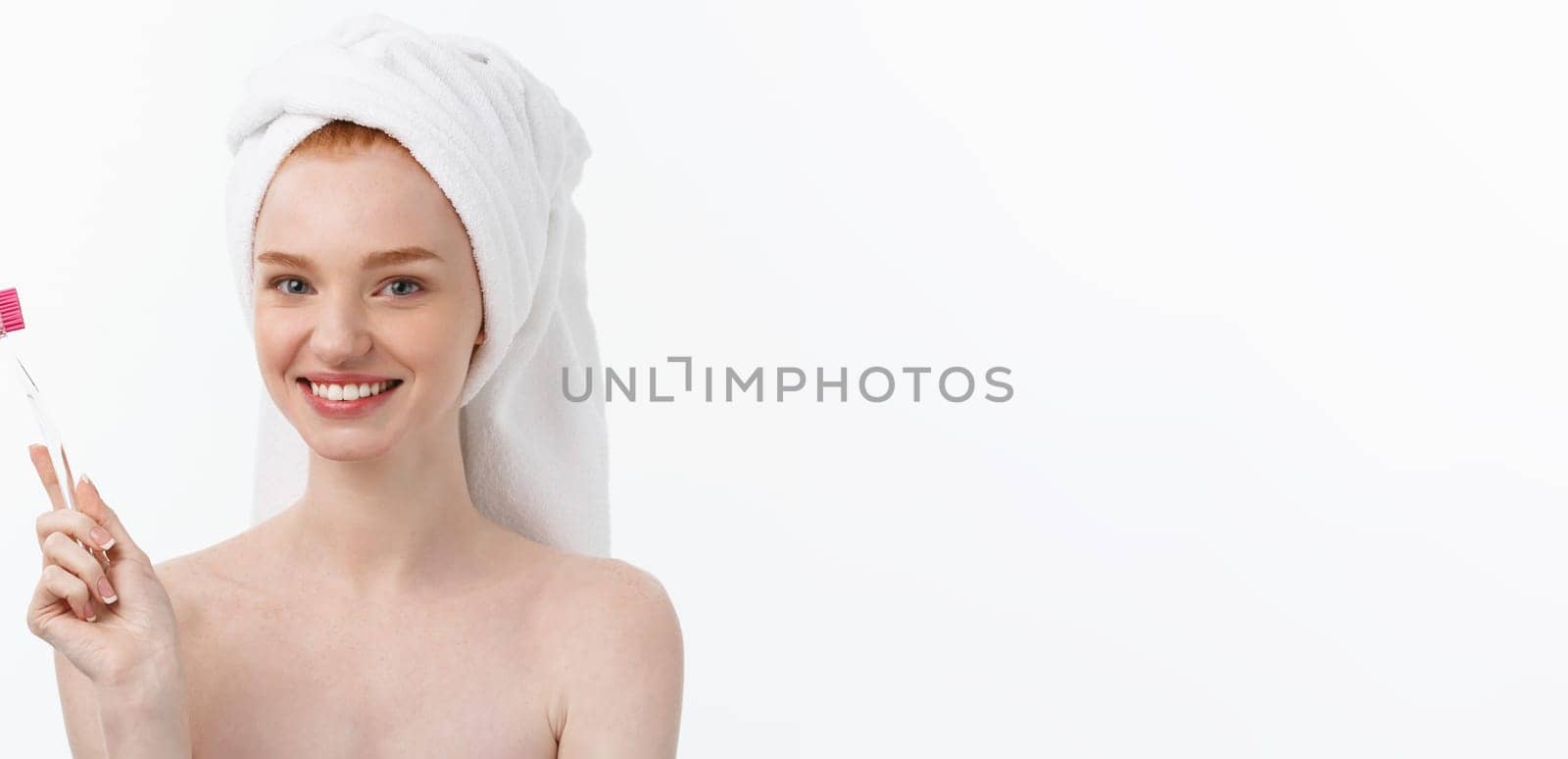 Portrait of young woman with toothbrush on grey background