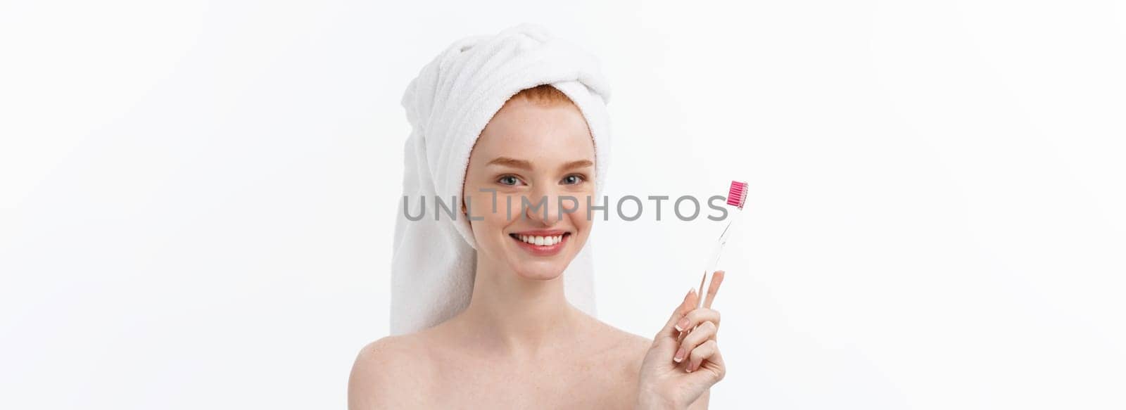 Portrait of young woman with toothbrush on grey background