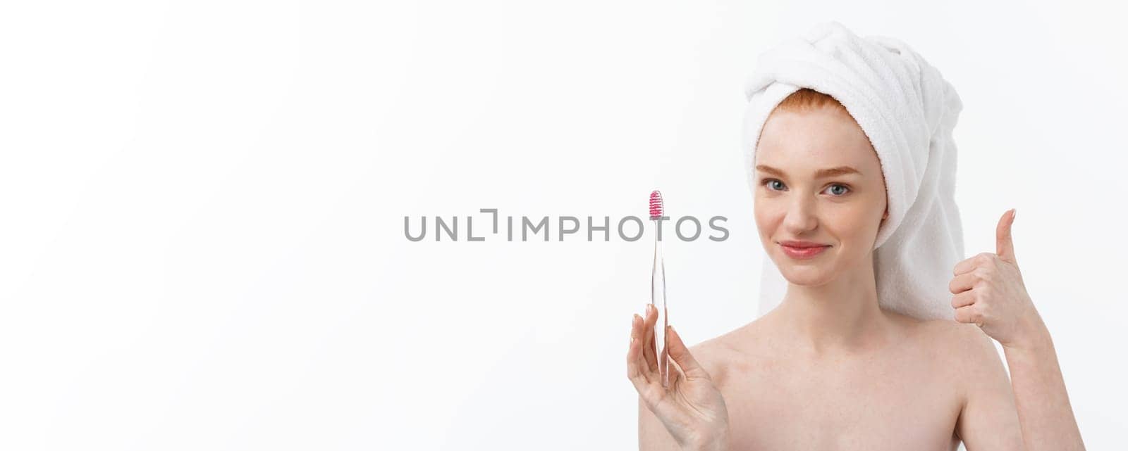 Portrait of young woman with toothbrush on grey background