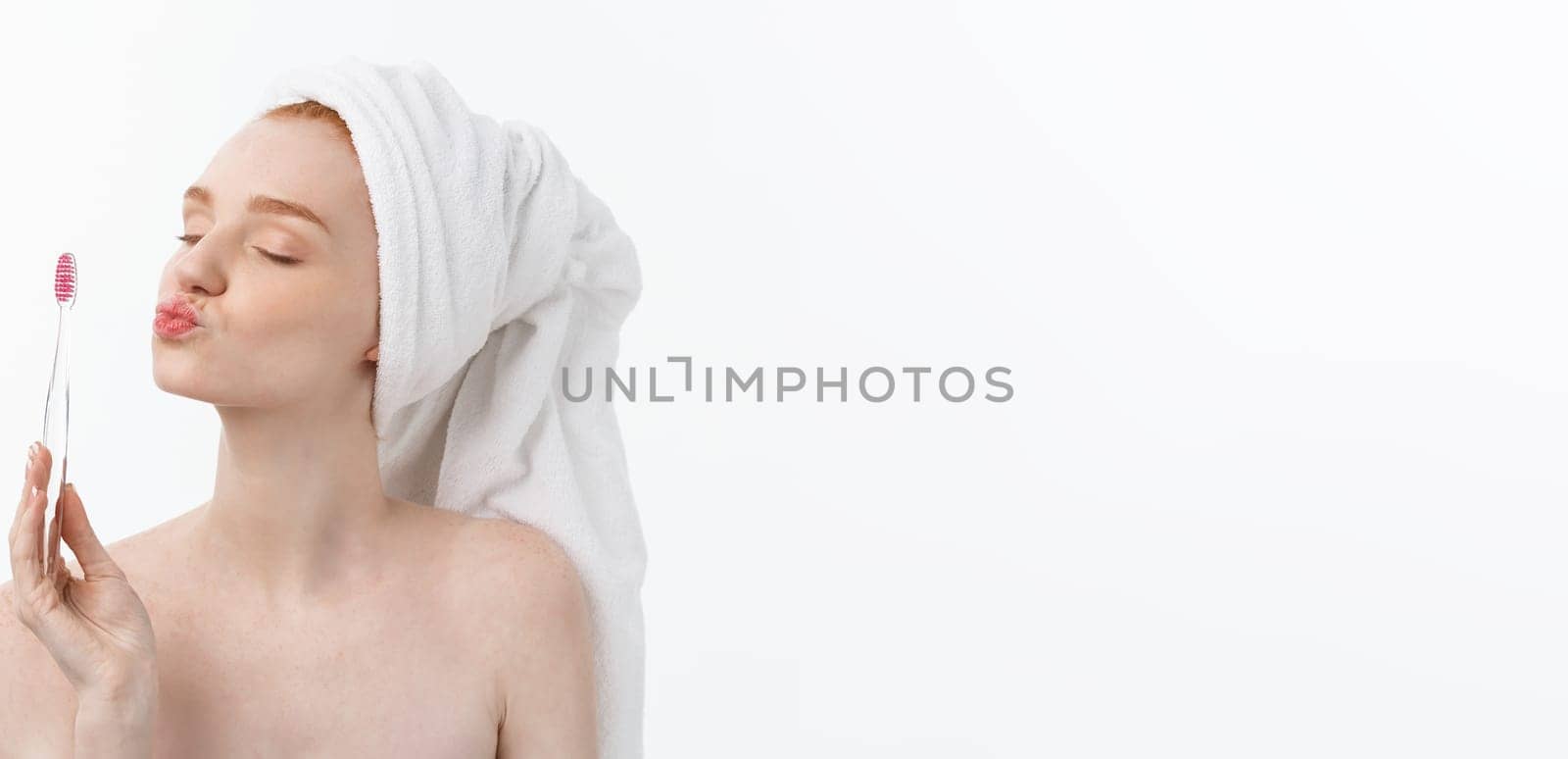 Portrait of young woman with toothbrush on grey background
