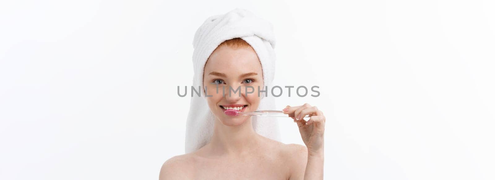 Portrait of young woman with toothbrush on grey background
