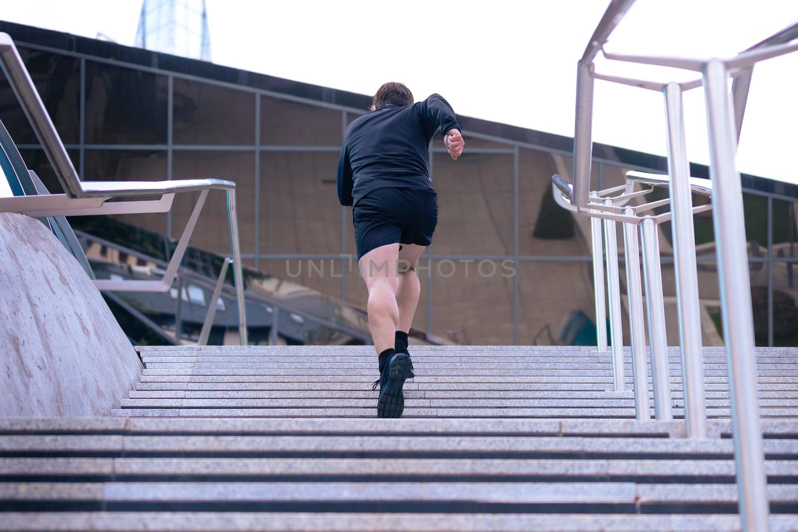 Athlete, running down the stairs, doing dynamic exercise outdoors by molesjuny