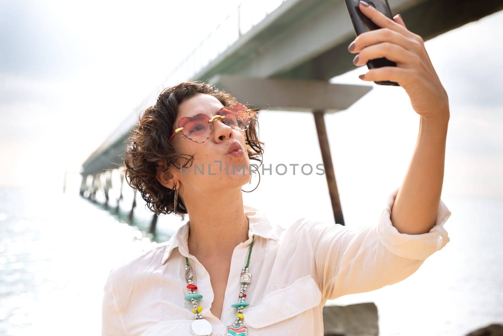 Young latin woman taking a selfie on the beach. Vacation and technology concepts