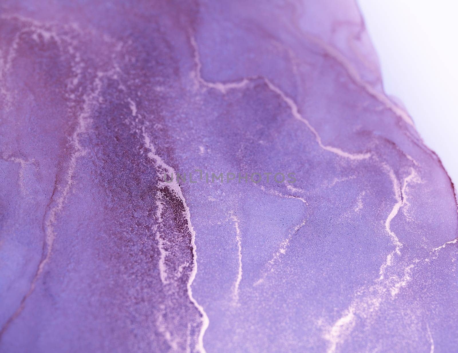 A close-up abstract image of purple and white ink swirling and merging on a white background.