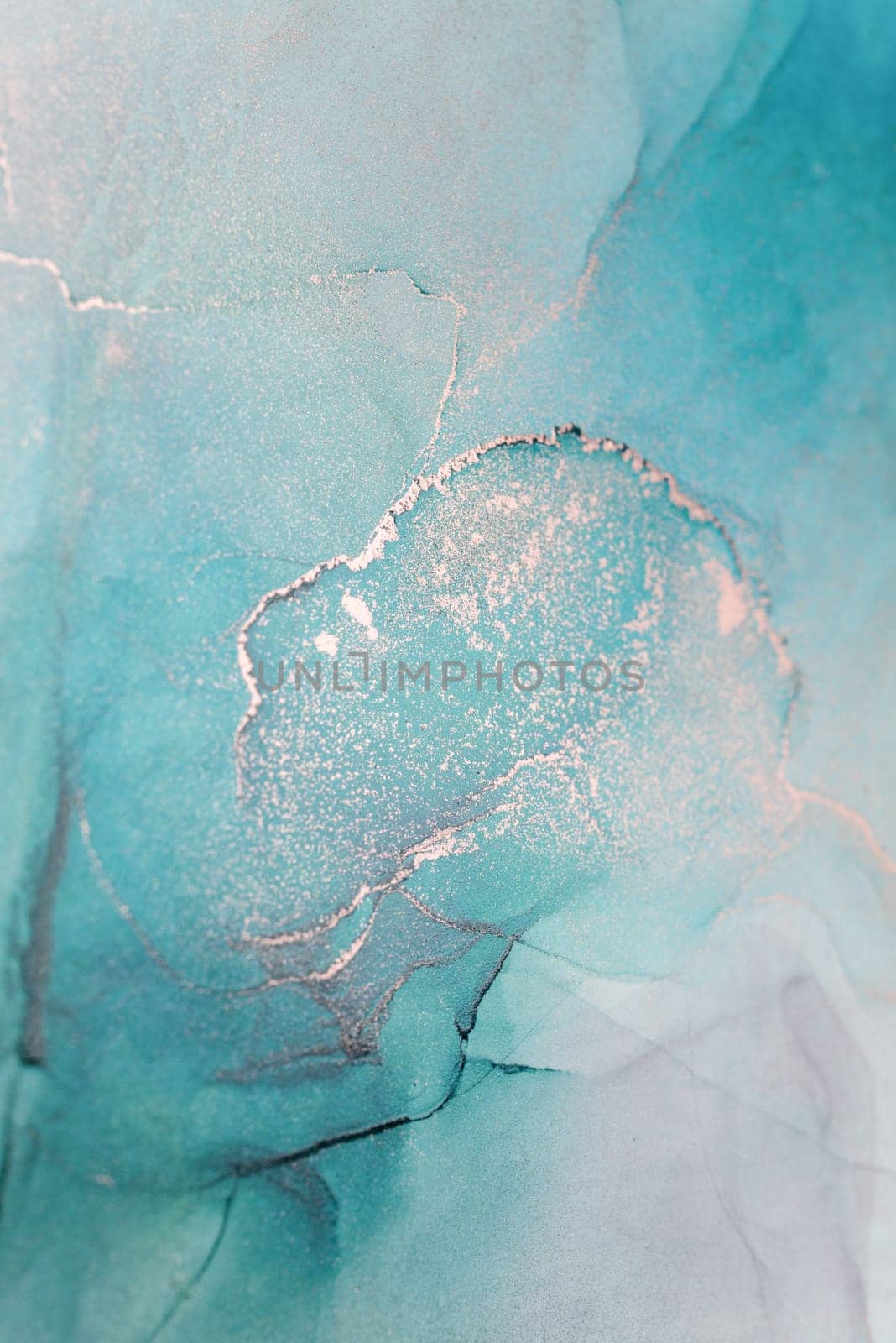 A close-up abstract image of teal and silver ink swirling and mixing together, creating a unique and intricate pattern.