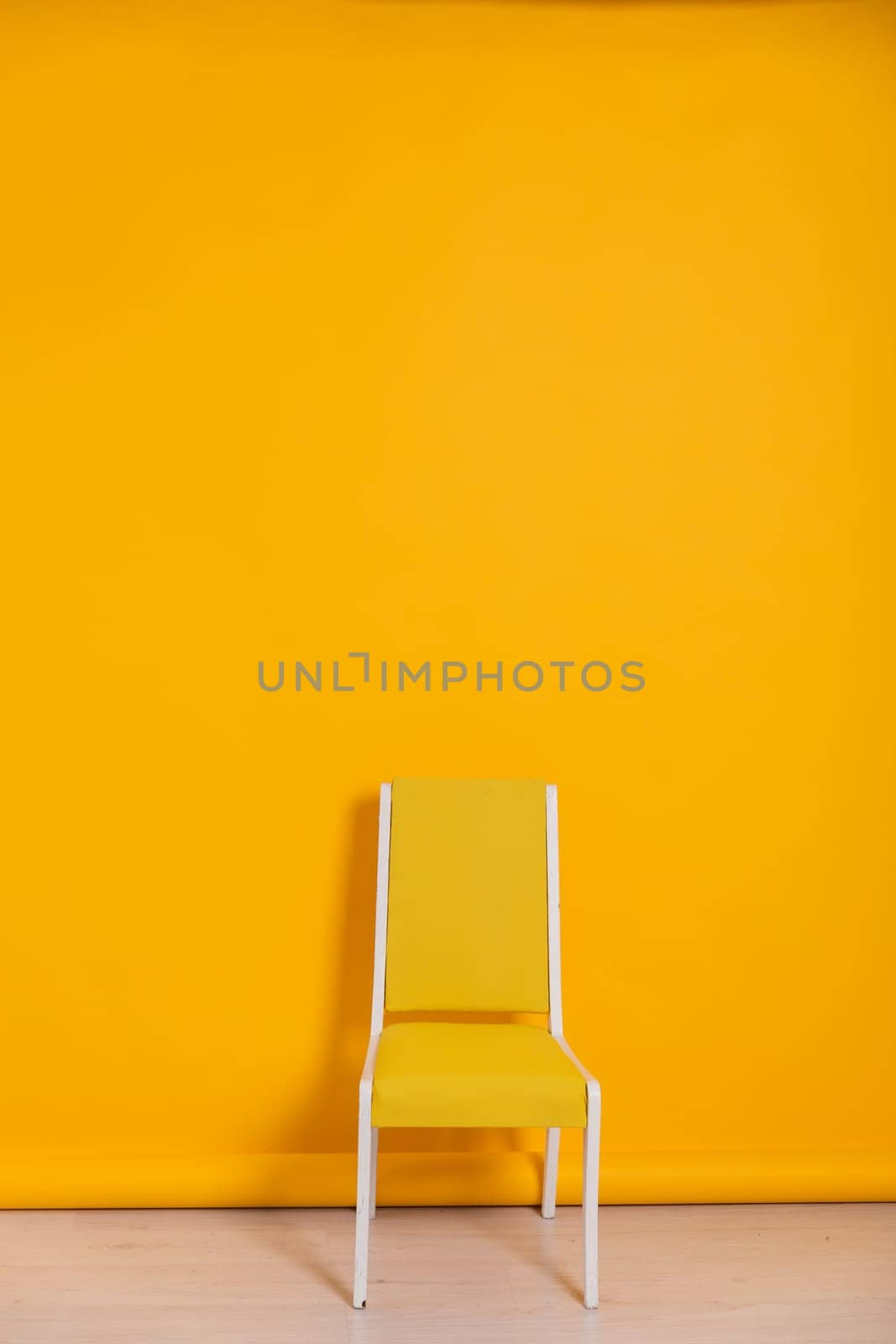 yellow chair in bright room against the wall of the same color interior furniture