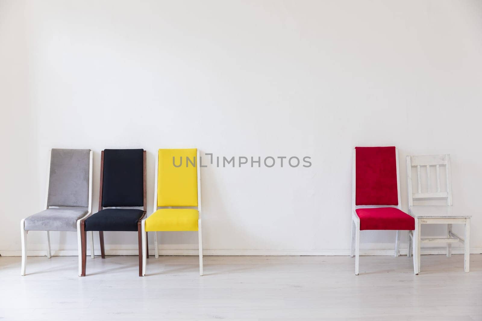 a yellow grey red black chairs in the interior of the white room