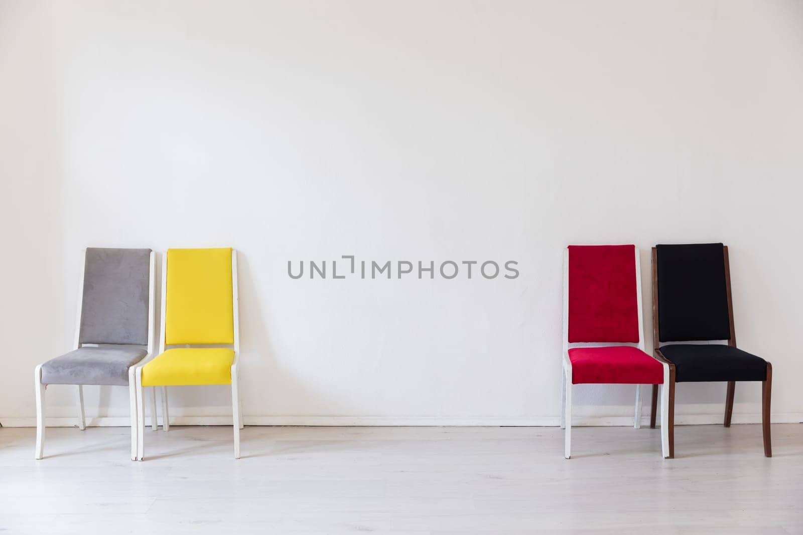 a bright room with four chairs grey red yellow black