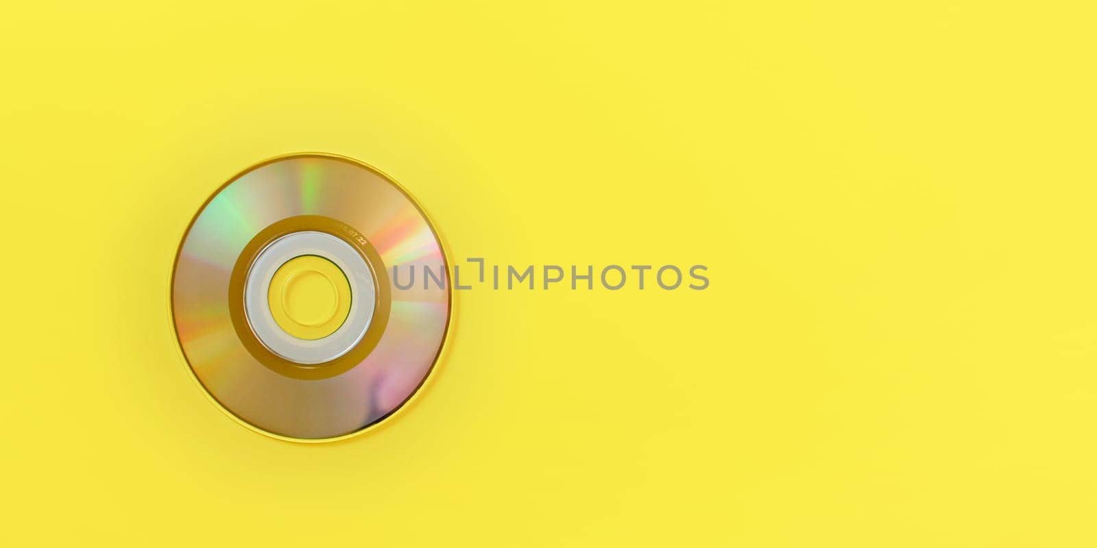 Top down view, small CD on yellow board, wide banner with space for text right. by Ivanko