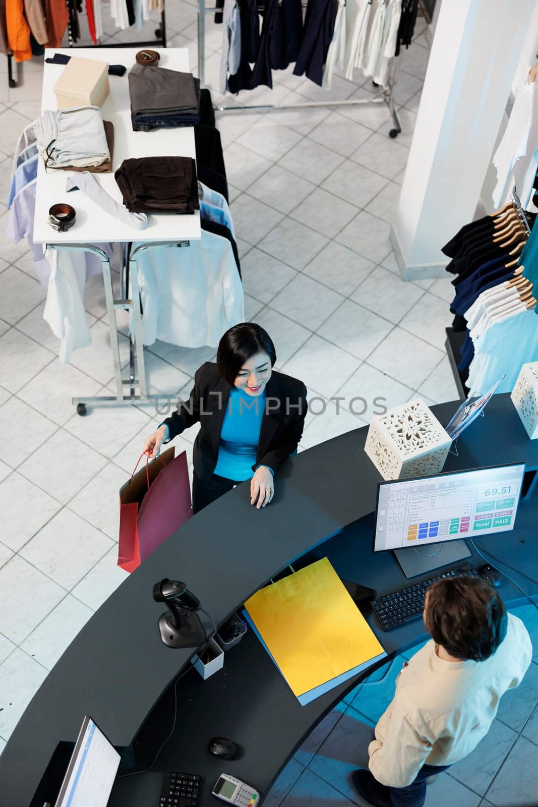 Woman talking with clothes store cashier by DCStudio