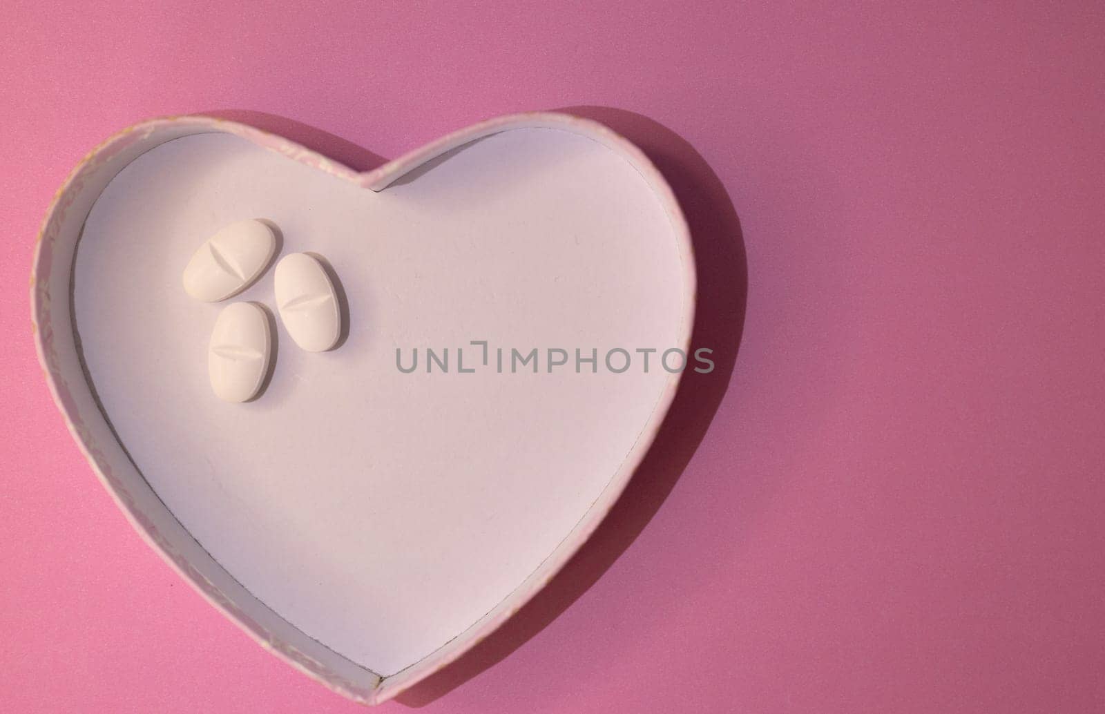 Top view or heart-shaped figure with white pills on one side Sapace for text. by VeroDibe